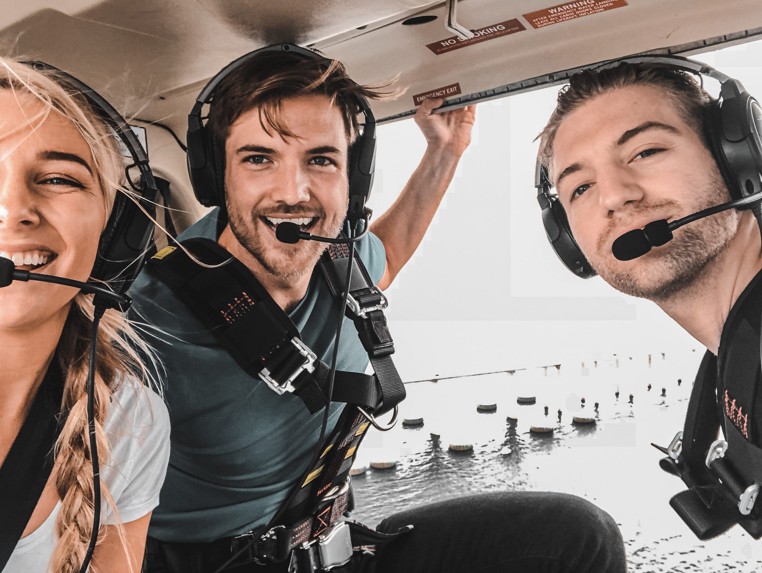 Group selfie of three people in helicopter
