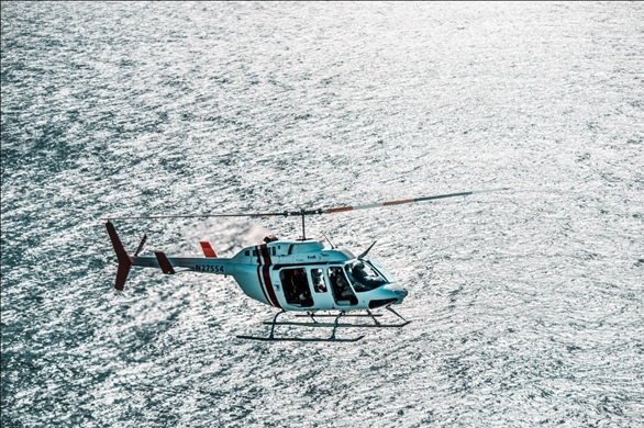 helicopter flying over ocean image