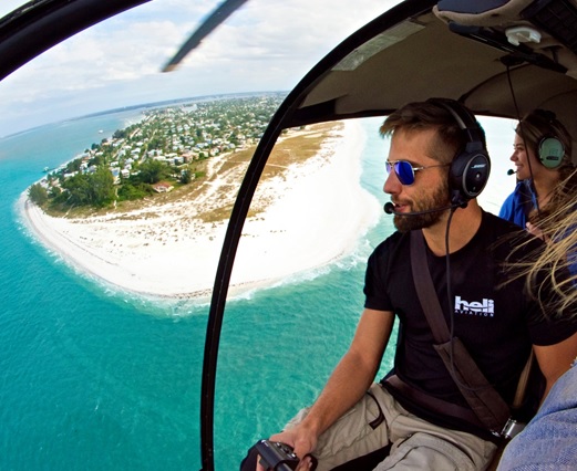 A pilot flying a helicopter beach tour in Florida.