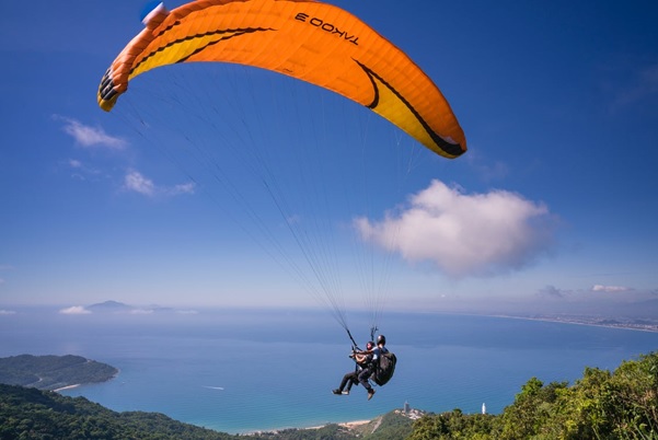 A skydiving instructor teaches trainee to release parachute in mid-air.