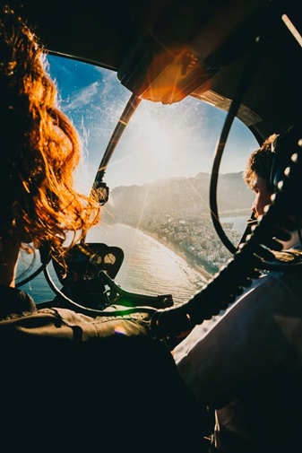 A person flying in a helicopter