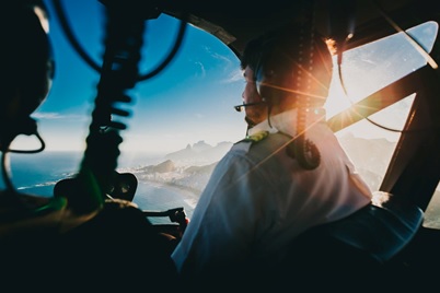 A helicopter pilot flying across the sea