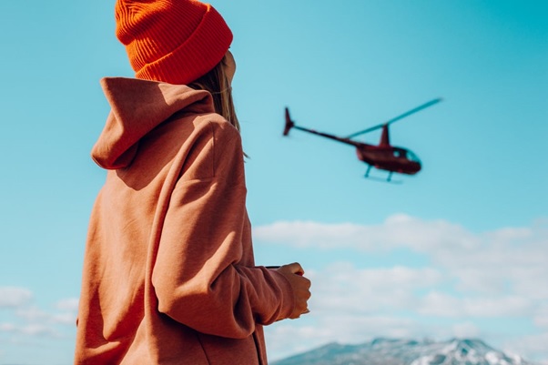 A girl watching a helicopter in the air