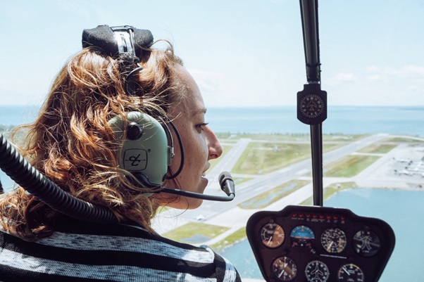 A woman taking a helicopter tour and wearing a headset